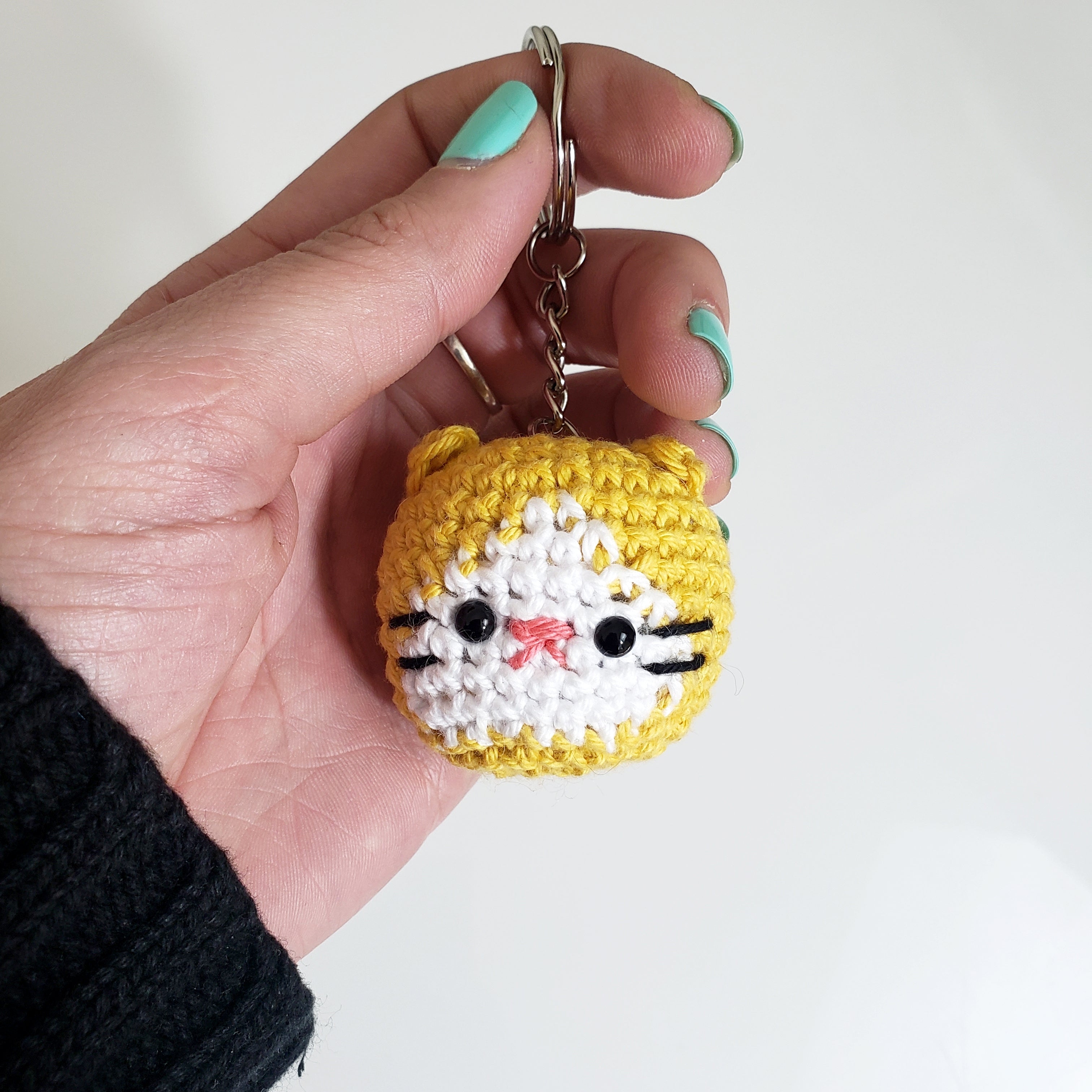 Mano sosteniendo a un Gatito Amigurumi Llavero