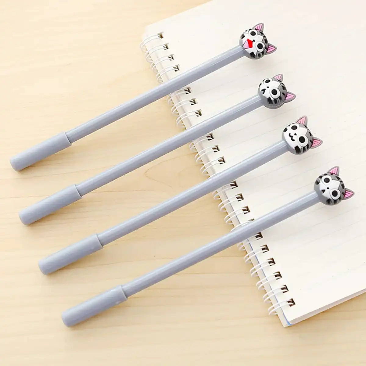 4 lápices cute de gatitos con diferentes caritas encima de un cuaderno