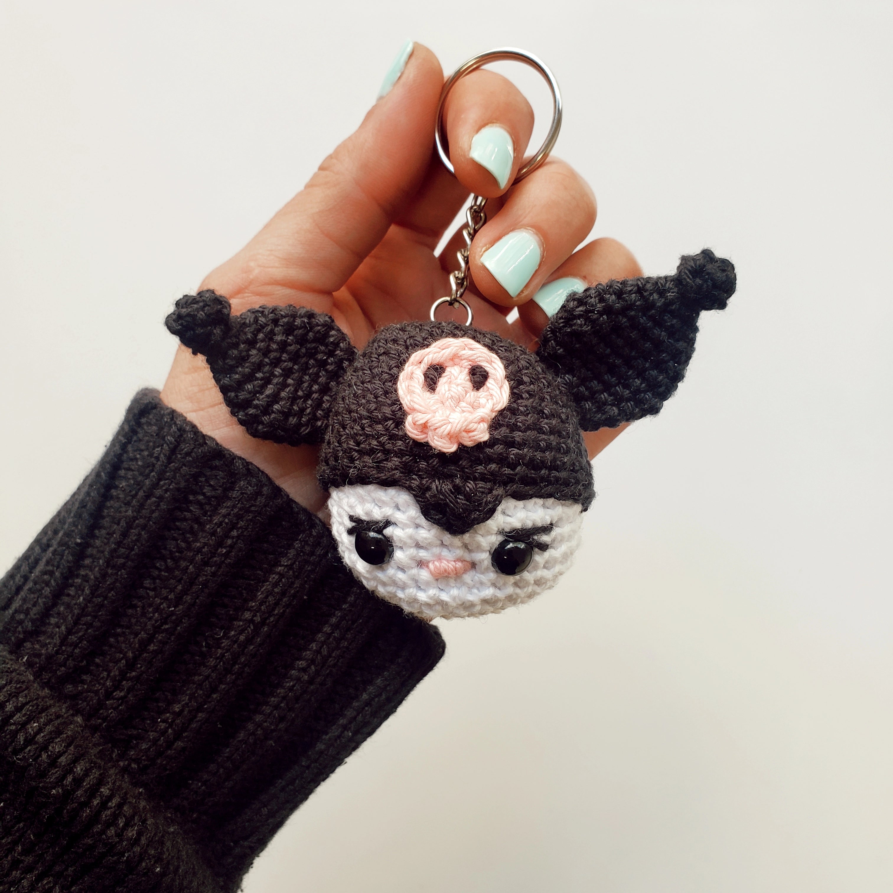 Llavero amigurumi Kuromi hecho a mano por artesano chileno, con gorrito negro y detalles bordados.