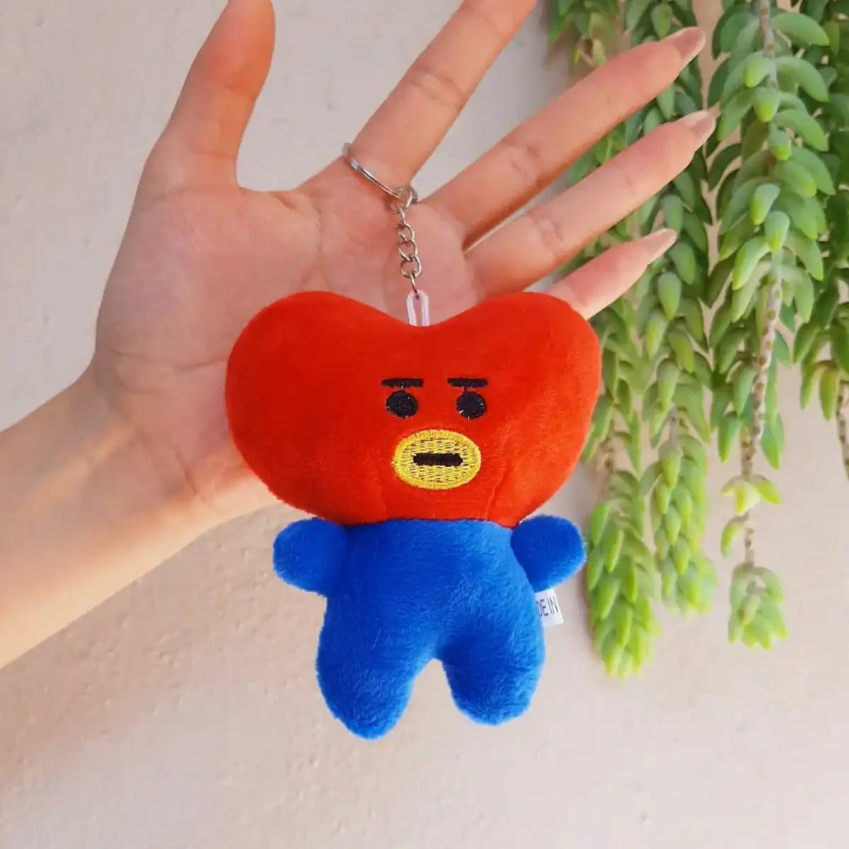 Llavero de Peluche Tata BT21 Colgado en la Mano de Una Mujer