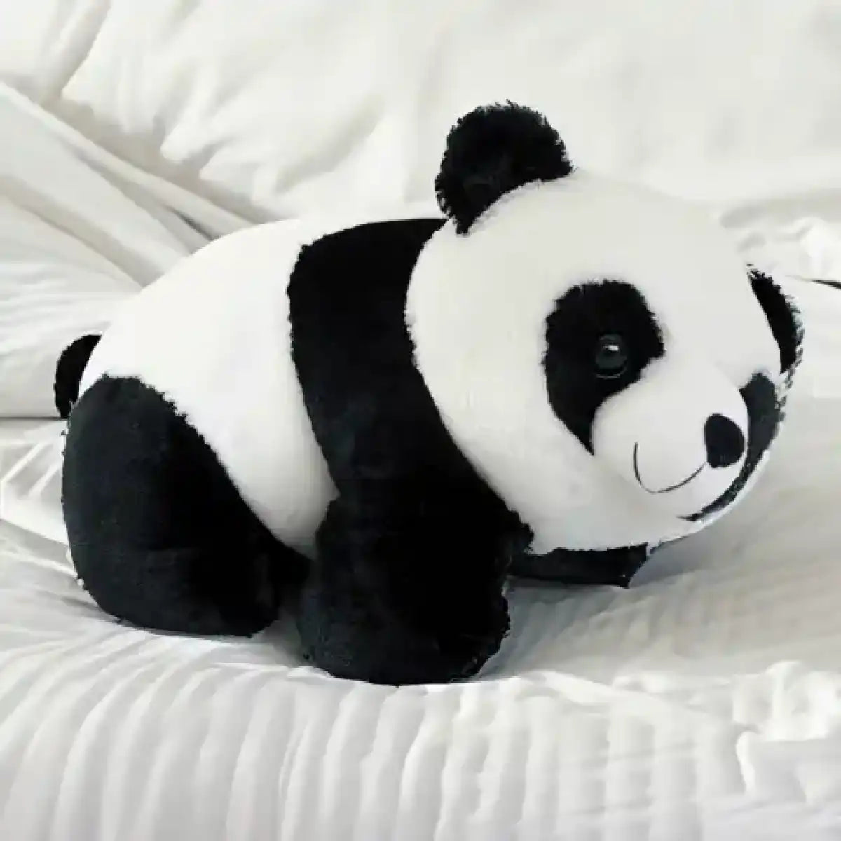 Un panda de peluche sobre una cama 